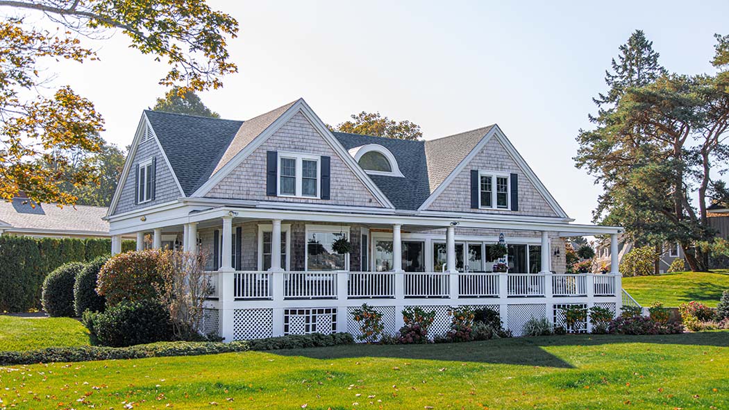 photo of quaint home with green grass surrounding it
